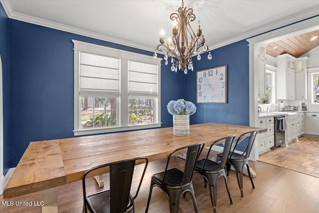 dining area featuring a notable chandelier, light wood-type flooring, and ornamental molding