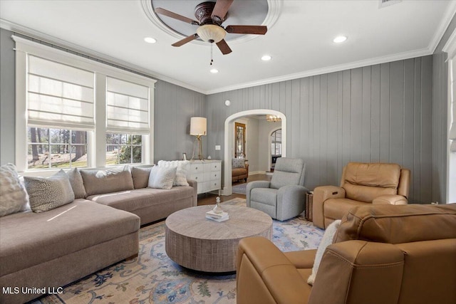 living area featuring arched walkways, recessed lighting, a ceiling fan, and ornamental molding