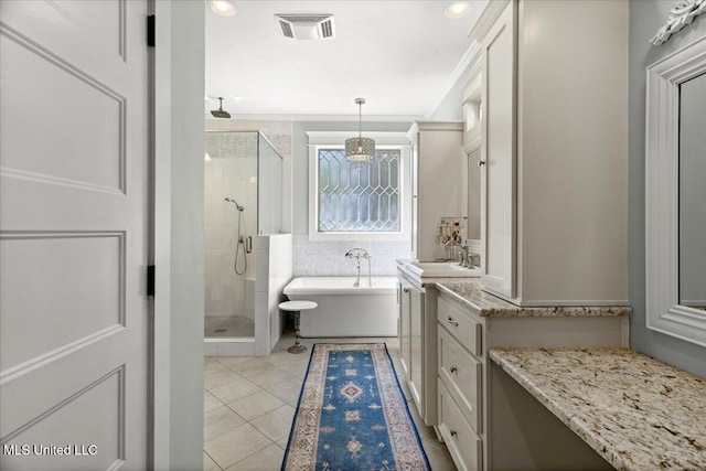 bathroom with visible vents, a shower stall, tile patterned flooring, a freestanding bath, and vanity