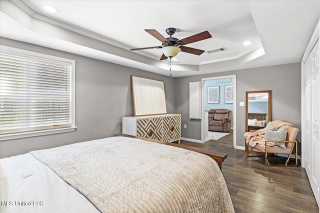 bedroom with visible vents, a tray ceiling, wood finished floors, recessed lighting, and baseboards