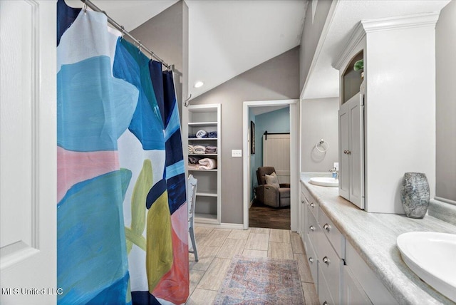 full bath with a sink, double vanity, and wood finish floors