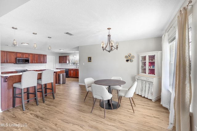 dining space featuring an inviting chandelier and light hardwood / wood-style floors