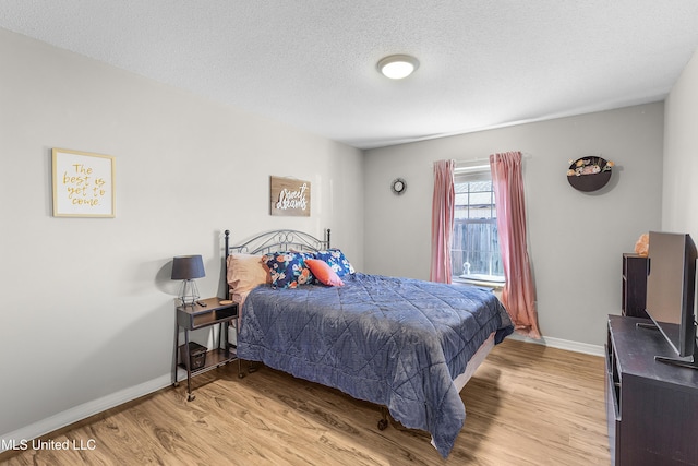 bedroom featuring a textured ceiling and light wood-type flooring