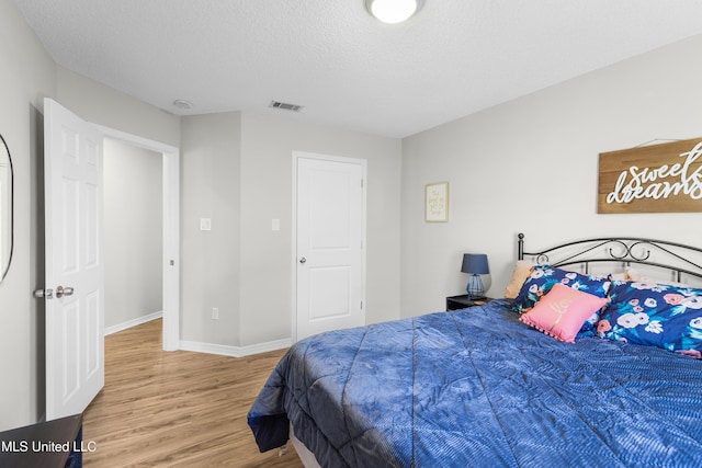 bedroom featuring wood-type flooring and a textured ceiling