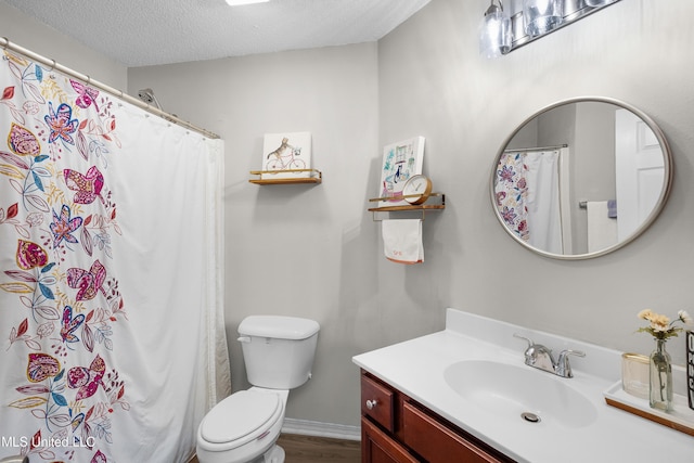 bathroom with vanity, toilet, and a textured ceiling