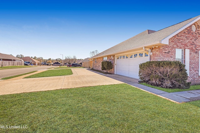 view of side of home featuring a garage and a yard