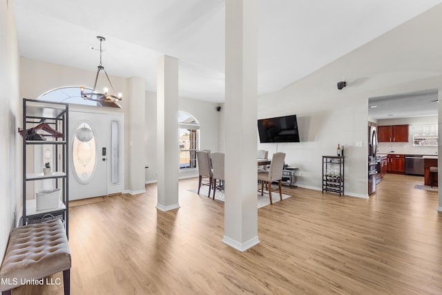 foyer entrance with a notable chandelier and hardwood / wood-style flooring