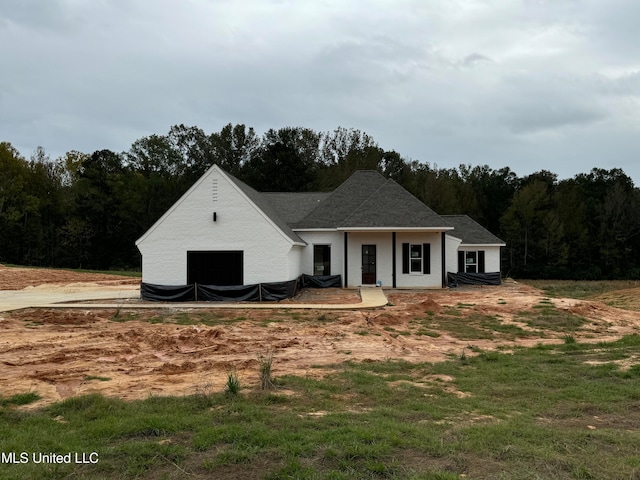 view of front of house with a wooded view