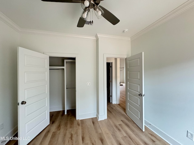 unfurnished bedroom with baseboards, a ceiling fan, crown molding, light wood-style floors, and a closet