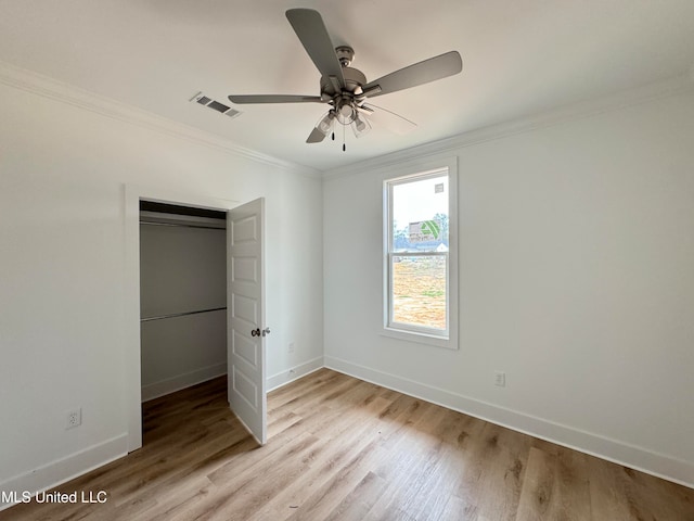 unfurnished bedroom featuring visible vents, crown molding, baseboards, and wood finished floors