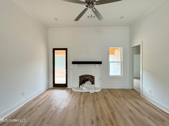 unfurnished living room featuring baseboards, a brick fireplace, wood finished floors, and crown molding