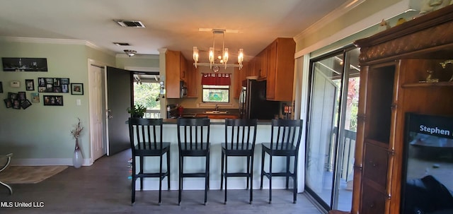 kitchen featuring crown molding, a healthy amount of sunlight, hanging light fixtures, and kitchen peninsula