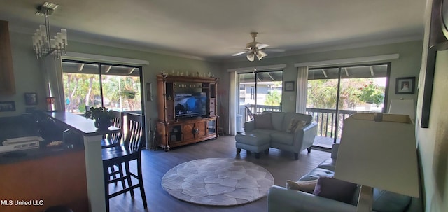 living room with crown molding, hardwood / wood-style flooring, ceiling fan with notable chandelier, and plenty of natural light