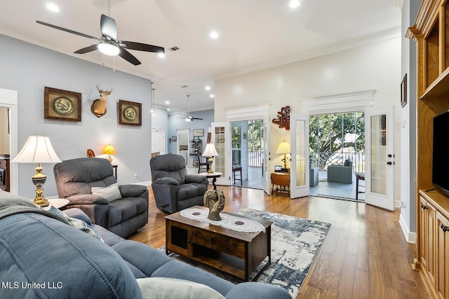 living room with hardwood / wood-style floors, ceiling fan, crown molding, and french doors