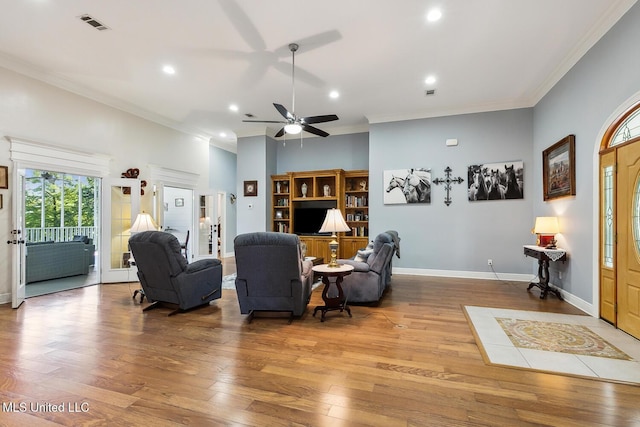 living room featuring wood-type flooring, ceiling fan, and crown molding