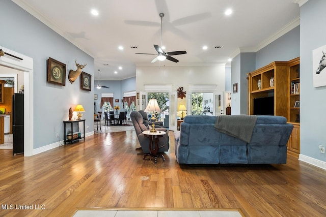 living room featuring ceiling fan, wood-type flooring, and ornamental molding