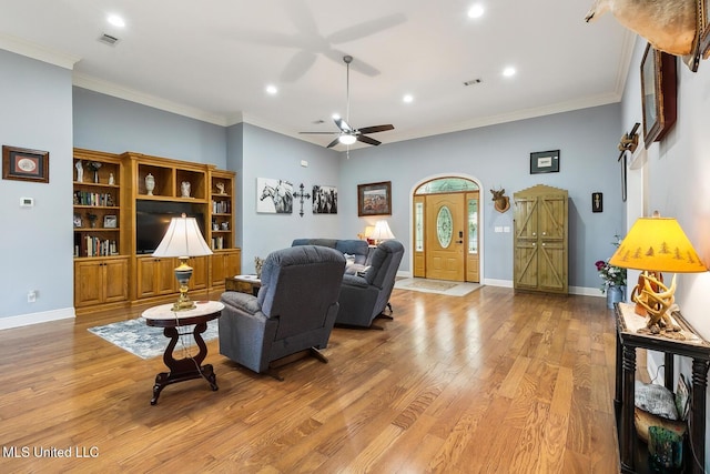 living room featuring light hardwood / wood-style flooring, ceiling fan, and ornamental molding