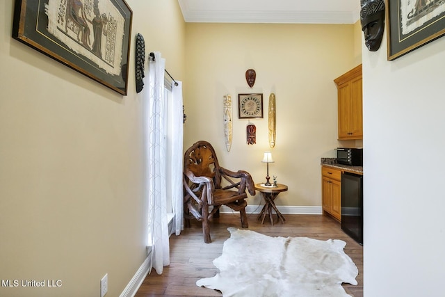 living area featuring wood-type flooring and crown molding