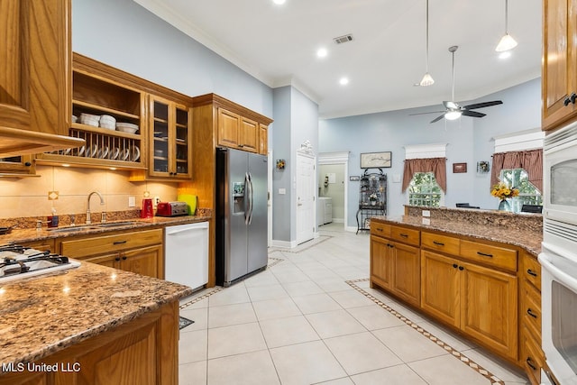 kitchen featuring stone counters, sink, ceiling fan, white appliances, and light tile patterned flooring