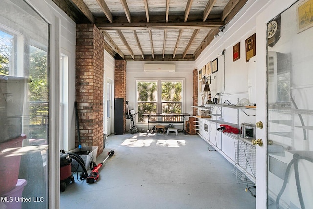 miscellaneous room featuring a wall unit AC, concrete floors, and brick wall