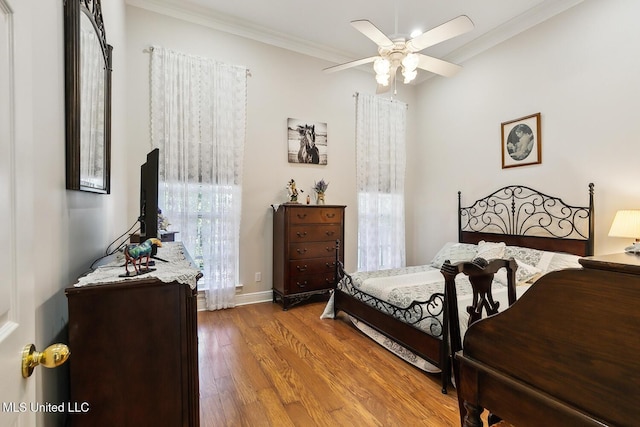 bedroom featuring hardwood / wood-style floors, ceiling fan, and crown molding