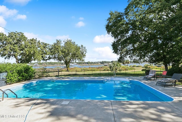 view of swimming pool with a patio area and a water view