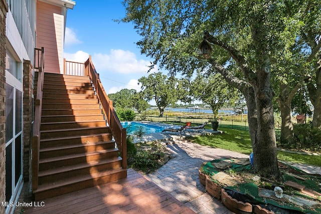 wooden deck featuring a patio area and a lawn