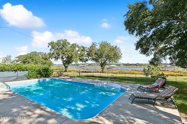 view of swimming pool featuring a patio, a water view, and a lawn