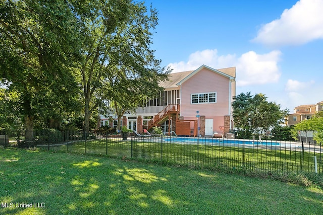 rear view of property featuring a yard and a sunroom