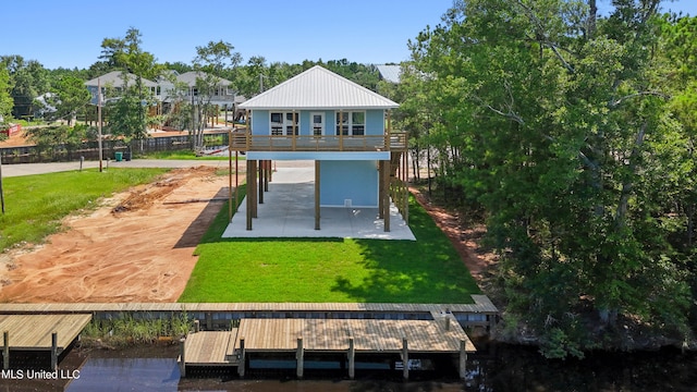 rear view of property with a balcony, a yard, and a patio