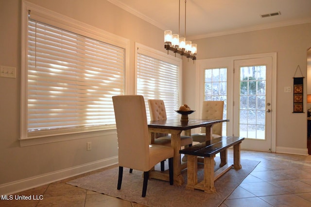 tiled dining area featuring a notable chandelier and ornamental molding