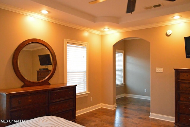 unfurnished bedroom with ceiling fan, a tray ceiling, crown molding, and dark hardwood / wood-style floors