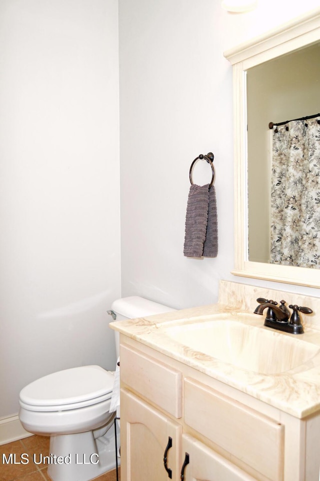 bathroom with vanity, tile patterned flooring, and toilet