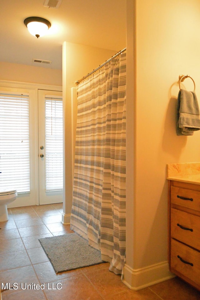 bathroom with a shower with curtain, tile patterned flooring, toilet, and vanity