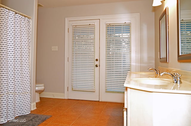 bathroom with toilet, tile patterned flooring, walk in shower, and vanity