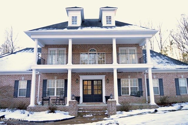 view of front of house with a porch, a balcony, and french doors