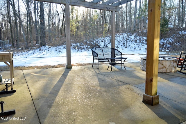 snow covered patio with a pergola