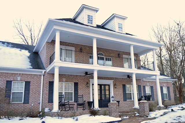 view of front facade with a balcony, ceiling fan, and covered porch