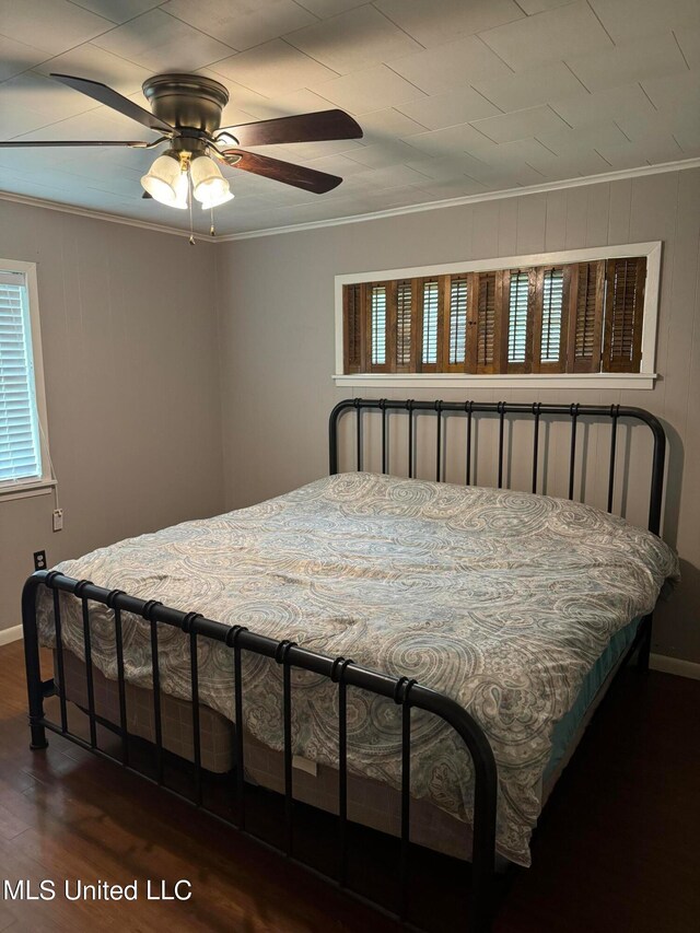 bedroom with dark hardwood / wood-style flooring, crown molding, multiple windows, and ceiling fan