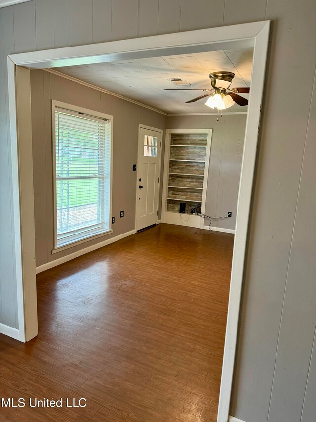 interior space with crown molding, hardwood / wood-style flooring, built in features, and ceiling fan