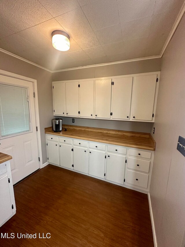 kitchen featuring butcher block countertops, crown molding, white cabinetry, and dark hardwood / wood-style flooring