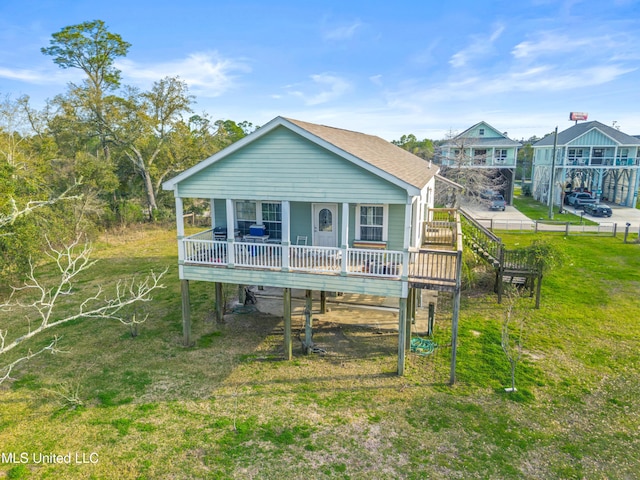 coastal inspired home featuring a front yard and a porch