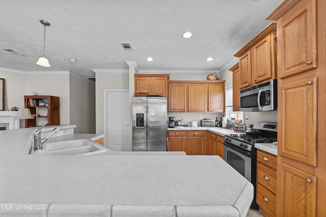 kitchen with visible vents, a sink, light countertops, appliances with stainless steel finishes, and pendant lighting