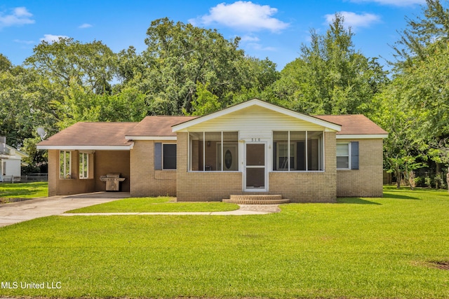 310 John Ave, Pascagoula, MS 39567 - view of front of house featuring brick siding, entry steps, concrete driveway, an attached carport, and a sunroom