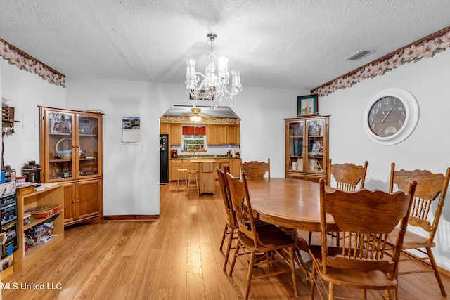 310 John Ave, Pascagoula, MS 39567 - dining area with a textured ceiling, a chandelier, and light wood-type flooring