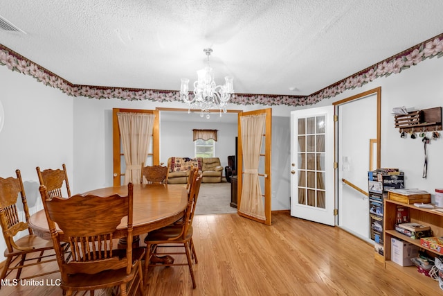 310 John Ave, Pascagoula, MS 39567 - dining area with a textured ceiling, a chandelier, and light wood-style floors