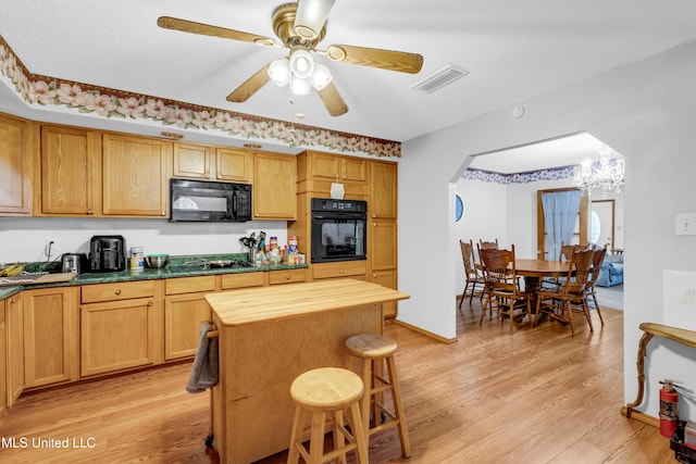 310 John Ave, Pascagoula, MS 39567 - kitchen featuring black appliances, butcher block countertops, light wood-style flooring, a breakfast bar area, and arched walkways