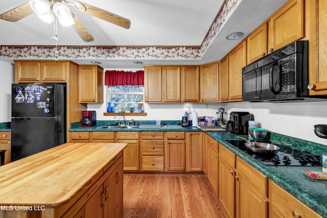 310 John Ave, Pascagoula, MS 39567 - kitchen with black appliances, light wood-style flooring, wood counters, a sink, and a textured ceiling