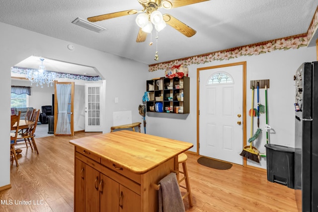 310 John Ave, Pascagoula, MS 39567 - kitchen featuring light wood-style flooring, freestanding refrigerator, butcher block counters, ceiling fan, and a textured ceiling