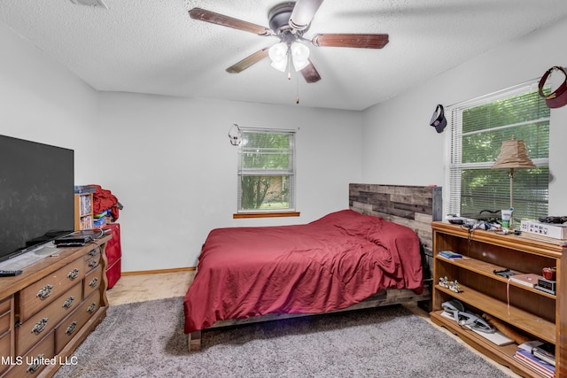 310 John Ave, Pascagoula, MS 39567 - bedroom featuring multiple windows, carpet, a textured ceiling, and a ceiling fan